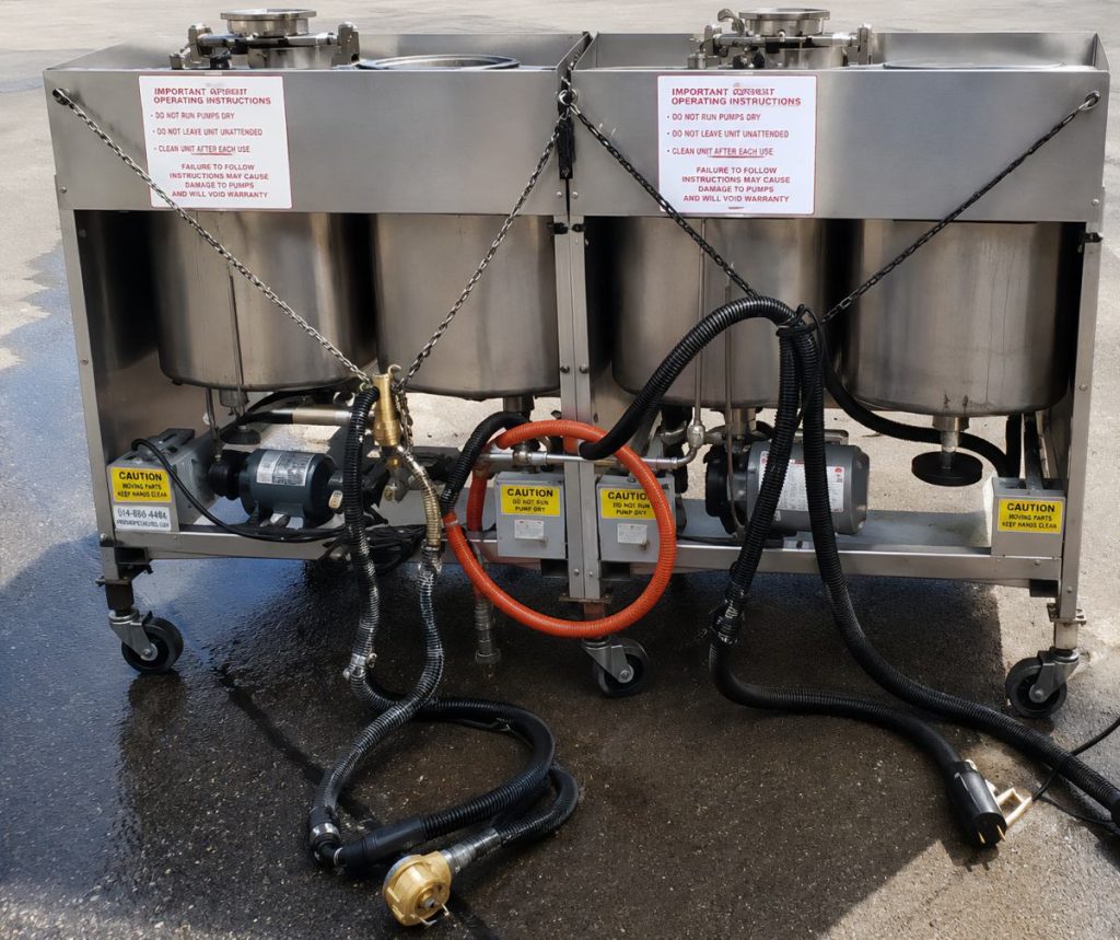 Industrial stainless steel cleaning unit with four tanks, pumps, and hoses on wheels.