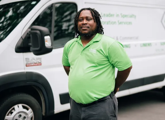 Prism Textiles employee in front of a branded service van