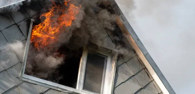 House with fire and smoke coming from a window