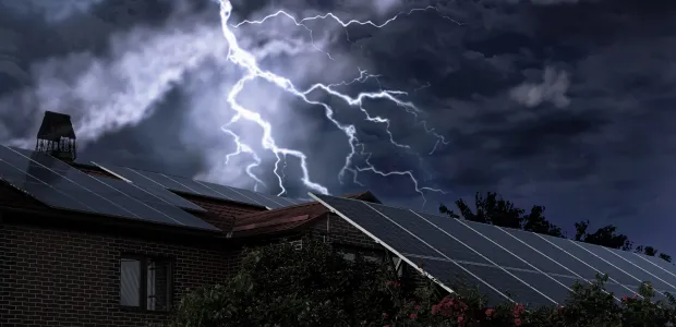 Home with solar panels during a lightning storm