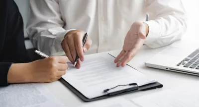 Two professionals reviewing a document on a clipboard