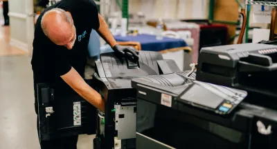 Prism technician servicing an office copier in a workshop
