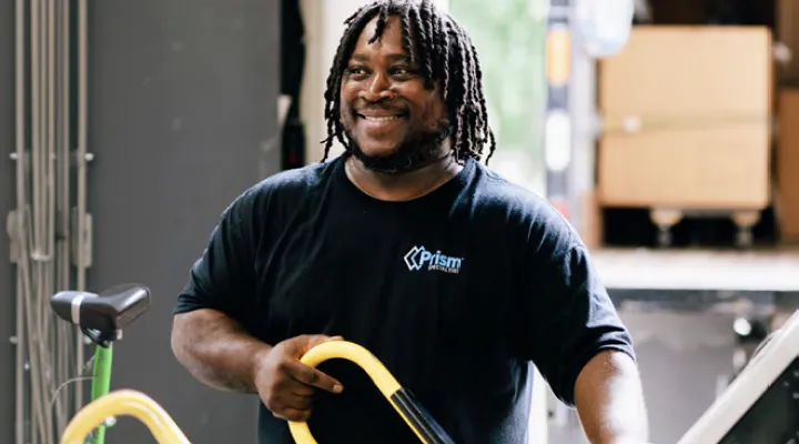 Prism technician with a hand truck at a loading dock