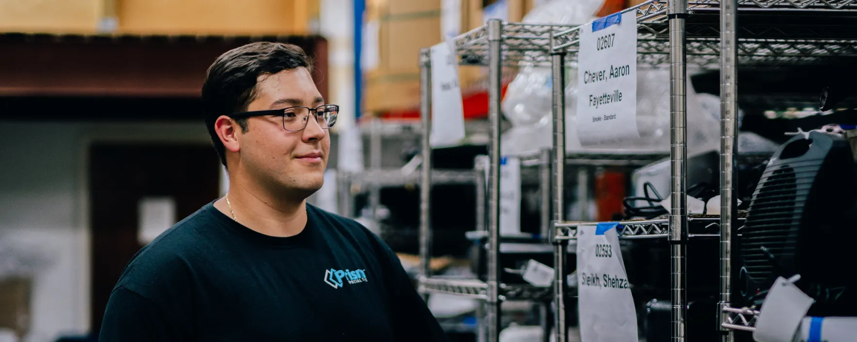 Prism technician reviewing labeled warehouse shelving