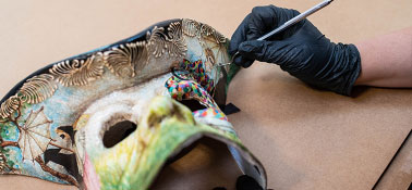 Person restoring a decorative mask