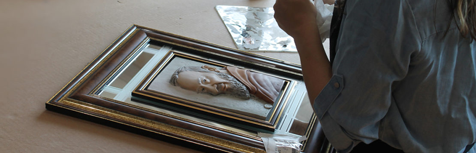 woman restoring framed art