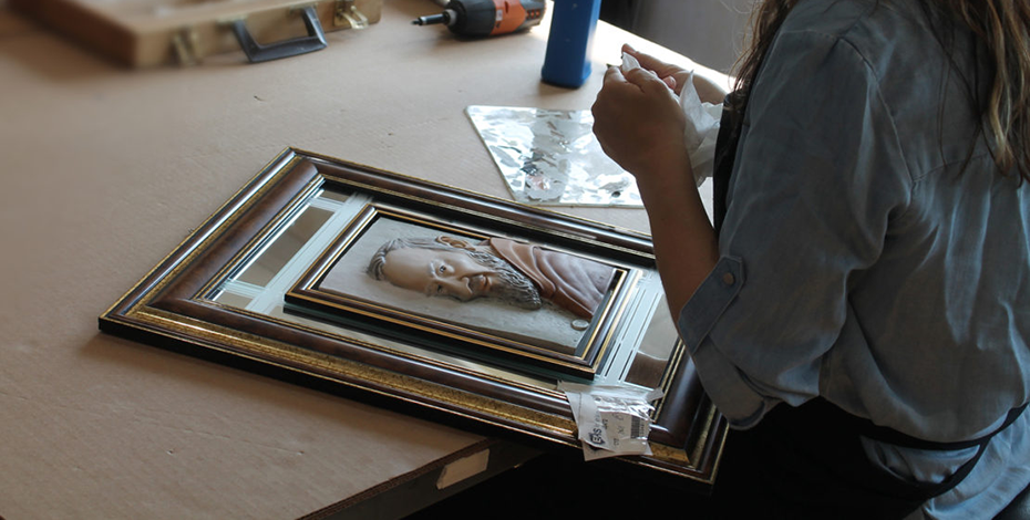 woman restoring framed art