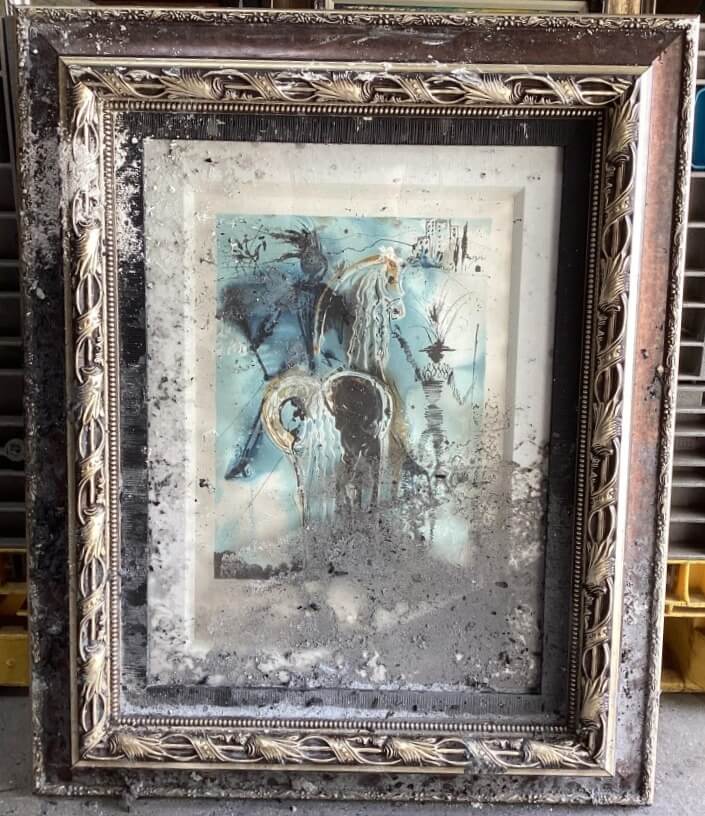 Framed artwork before restoration showing visible damage to both the painting and the original frame