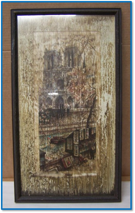 Framed artwork before restoration showing water damage, staining, and frame finish failure