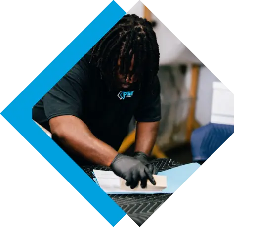 A worker wearing a company shirt and black gloves carefully smooths a light blue surface with