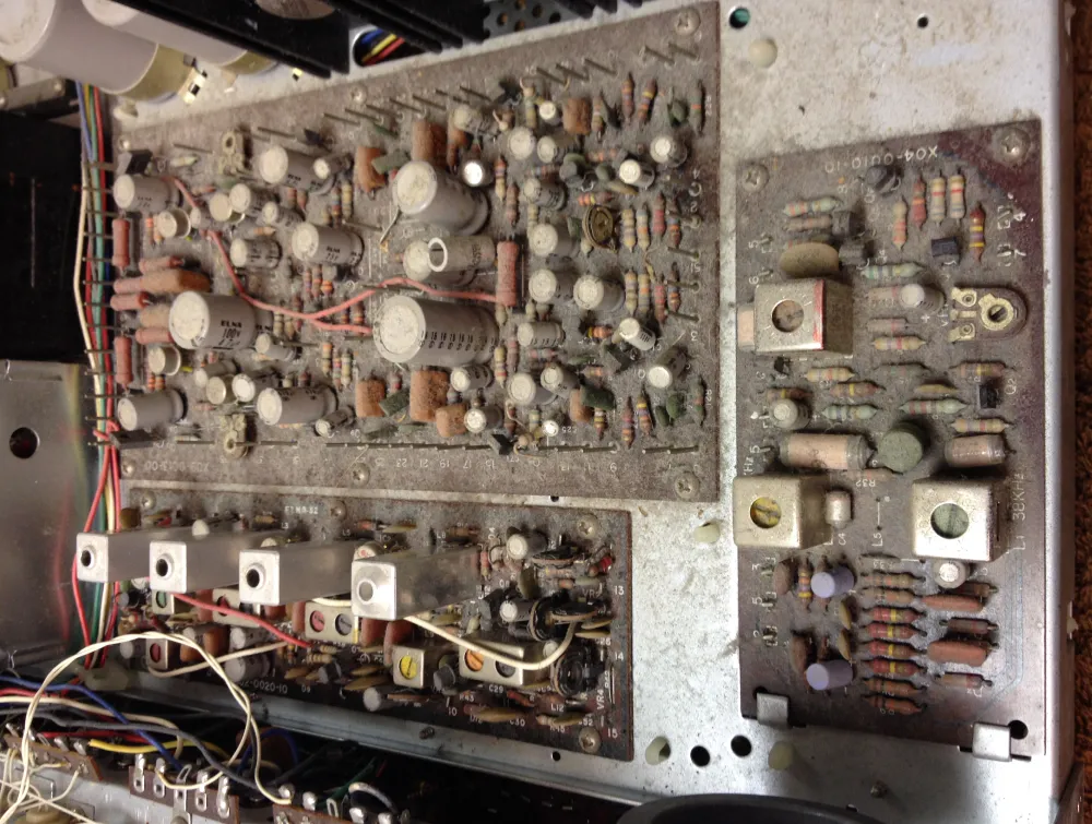 Dusty, vintage electronic circuit boards with numerous capacitors, resistors, and wires. TITLE: