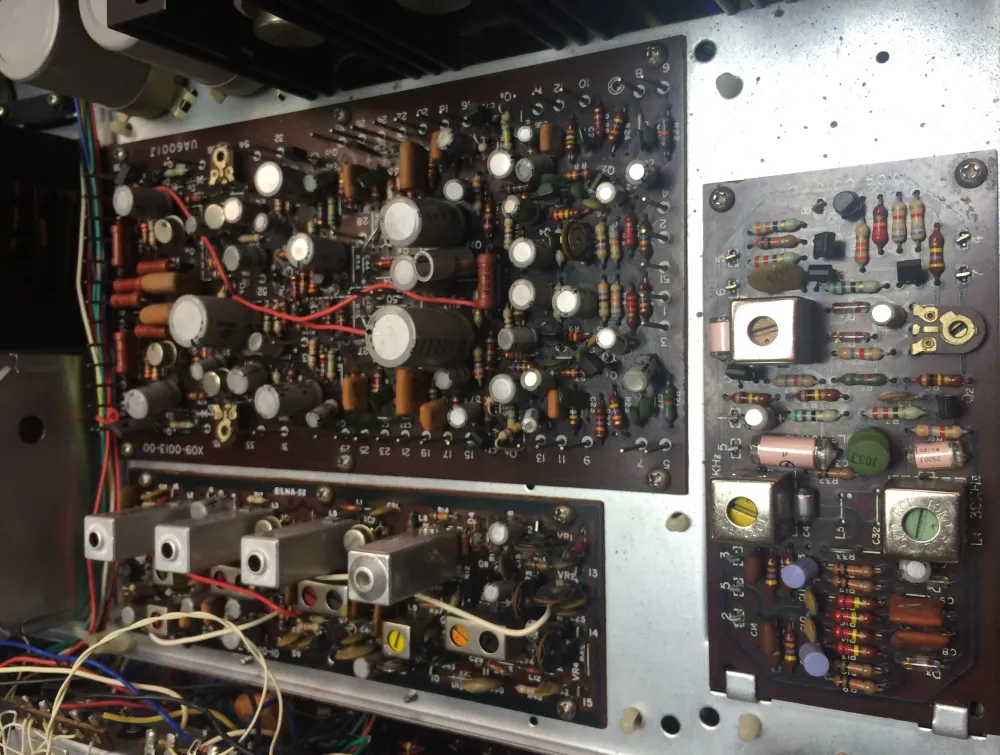 Internal view of vintage electronic equipment showing densely packed circuit boards with components and wiring.