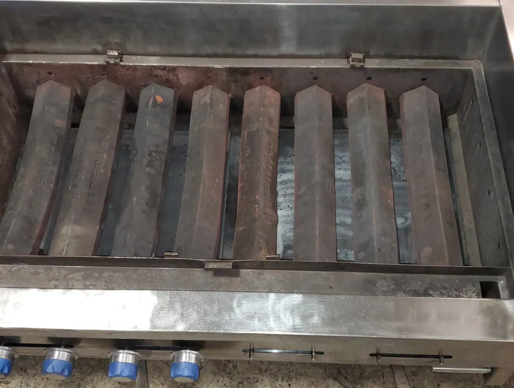 Used Imperial commercial charbroiler interior showing metal radiants and control knobs with blue-t